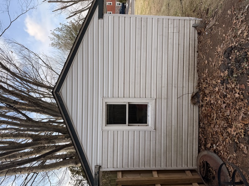 Before — old shed with stained siding