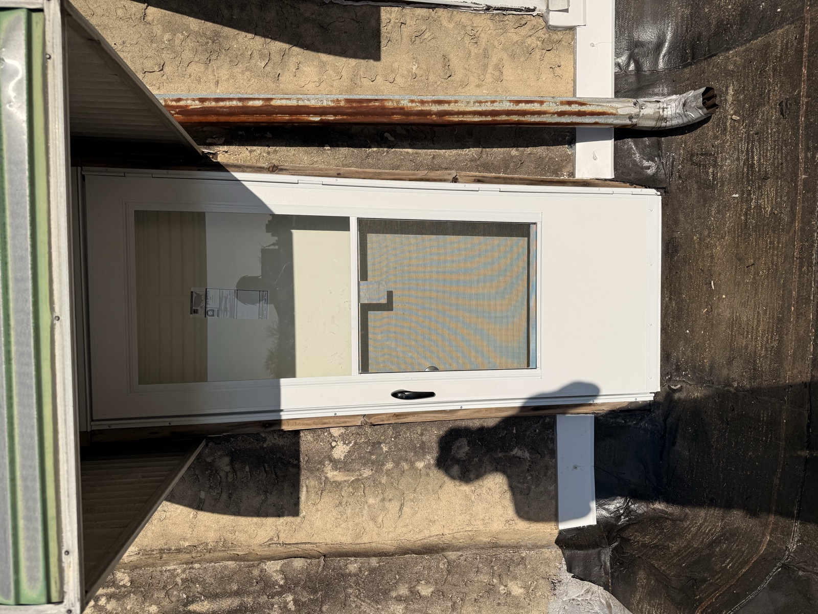 Exterior door after — new white slider installed